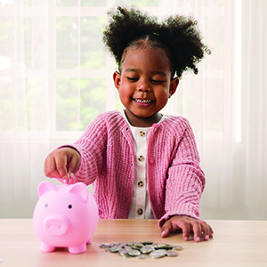 Girl putting money in piggy bank