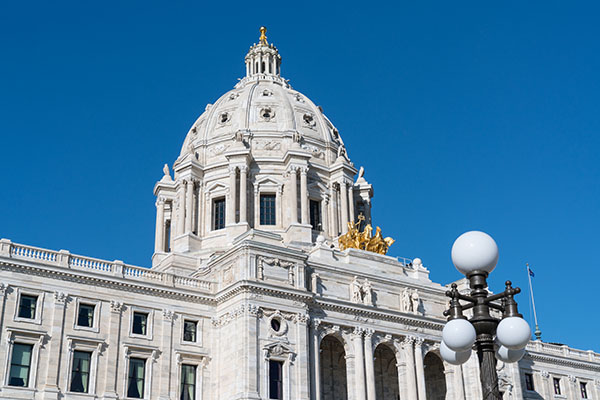 Exterior view of the Minnesota Capitol dome against a cloudless blue sky.