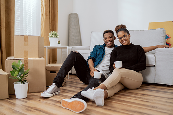 A couple taking a break while unpacking after moving.