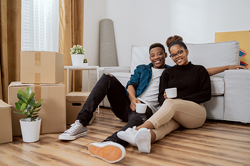 A 20-something-aged couple taking a break while unpacking after moving."
