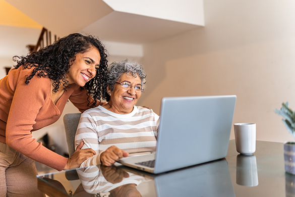 Two women looking at a laptop computer screen.