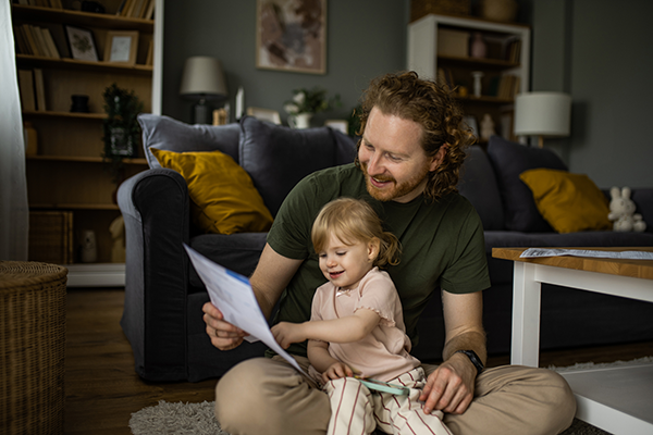 A father and young child sitting in their living room.